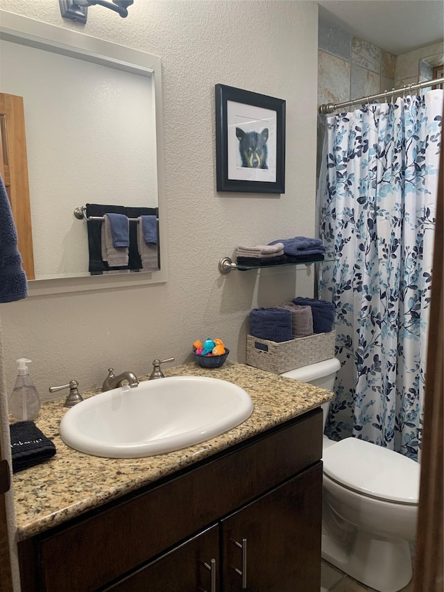 bathroom featuring a shower with curtain, vanity, and toilet