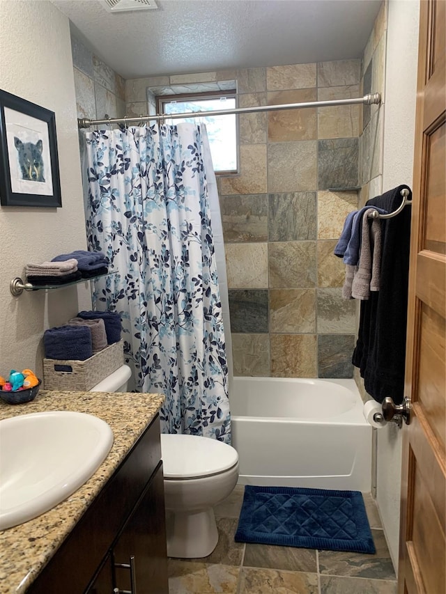 full bathroom featuring vanity, shower / bath combination with curtain, a textured ceiling, and toilet