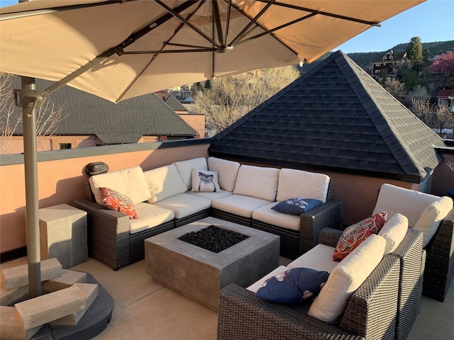 view of patio with a fire pit and a balcony