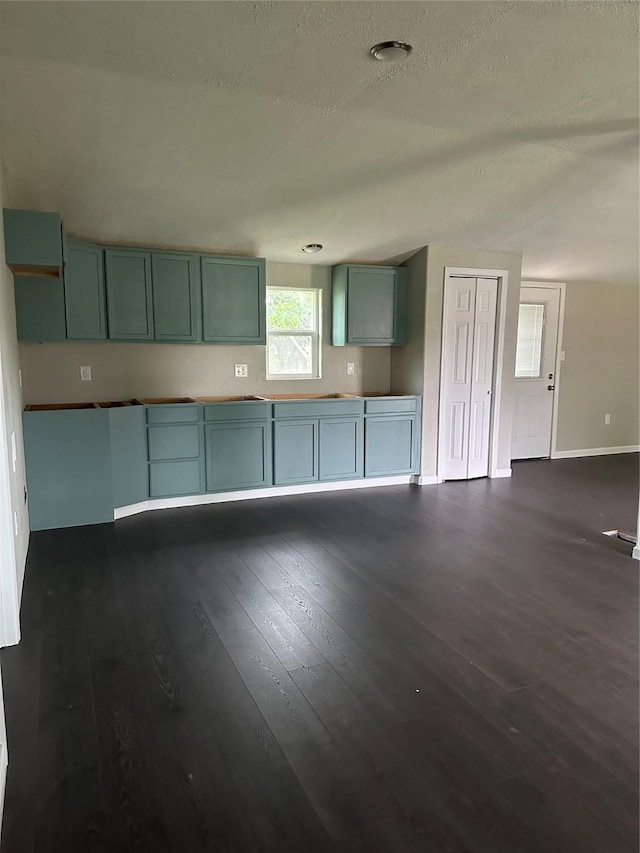 kitchen with dark hardwood / wood-style flooring, a textured ceiling, and green cabinetry