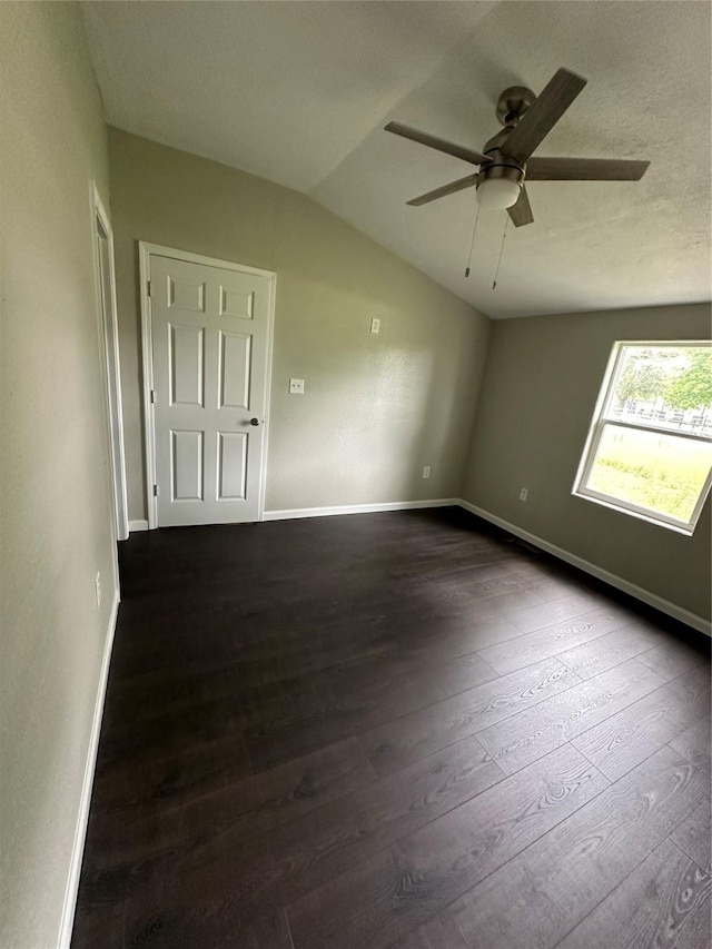 unfurnished room with dark hardwood / wood-style flooring, vaulted ceiling, and ceiling fan