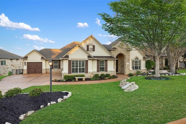 view of front facade with stone siding, concrete driveway, a front lawn, and stucco siding