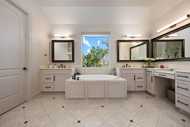 full bathroom with two vanities, a sink, a bath, and tile patterned floors