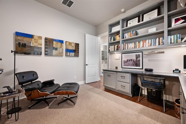 home office with baseboards, visible vents, wood finished floors, and built in study area