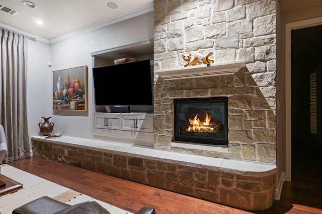 interior details featuring a fireplace, wood finished floors, visible vents, and crown molding