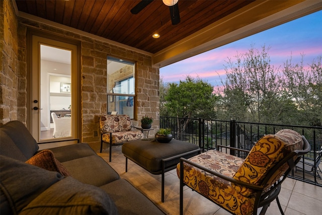 balcony at dusk with ceiling fan and an outdoor hangout area