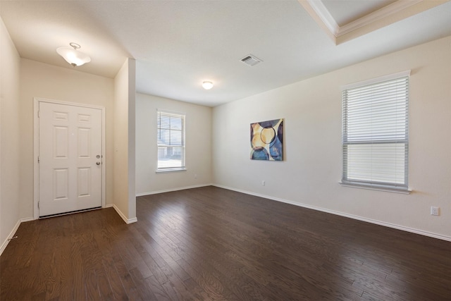 interior space featuring visible vents, baseboards, dark wood-type flooring, and crown molding