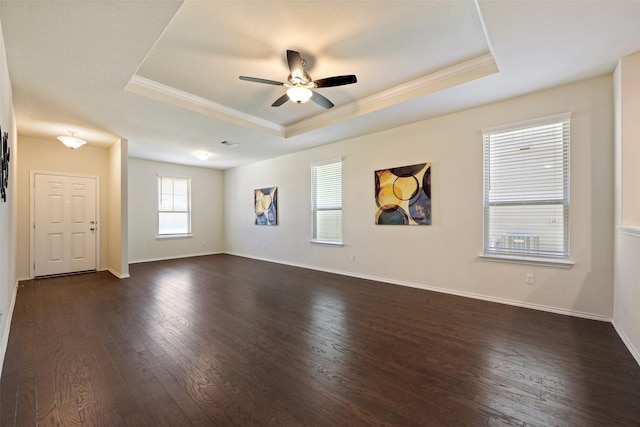 spare room featuring baseboards, a raised ceiling, and dark wood-style floors