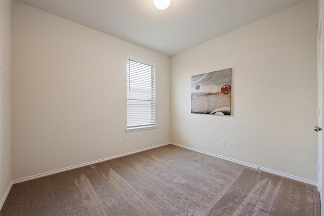 carpeted spare room with baseboards