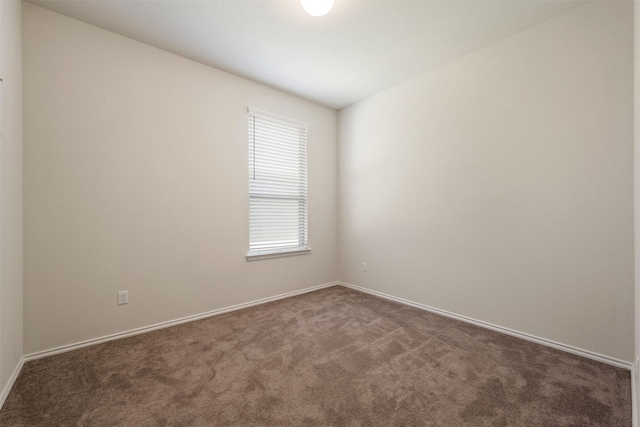 carpeted empty room featuring baseboards