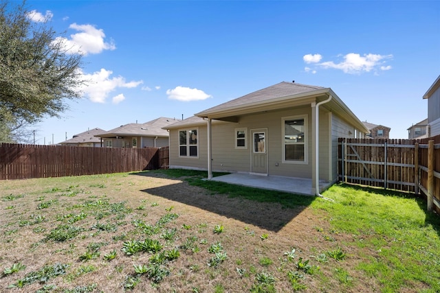 back of house with a fenced backyard, a yard, and a patio