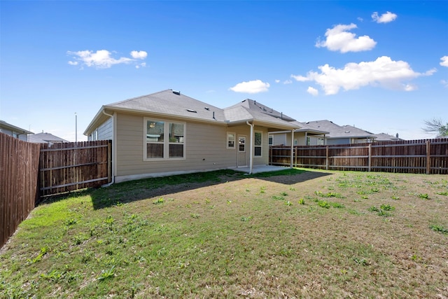 back of house with a patio area, a yard, and a fenced backyard