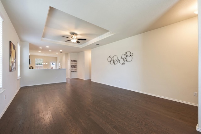 unfurnished living room with baseboards, ceiling fan, recessed lighting, a raised ceiling, and dark wood-style flooring