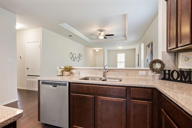 kitchen with a sink, decorative backsplash, a raised ceiling, dishwasher, and dark wood-style flooring