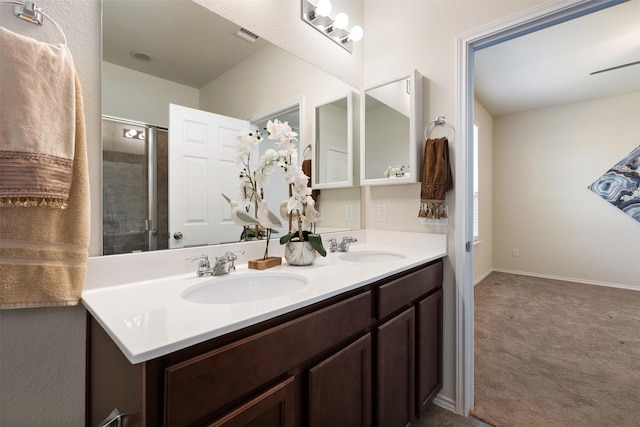 bathroom with double vanity, visible vents, a stall shower, and a sink