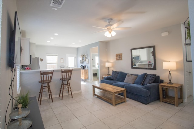 living room featuring light tile patterned floors and ceiling fan