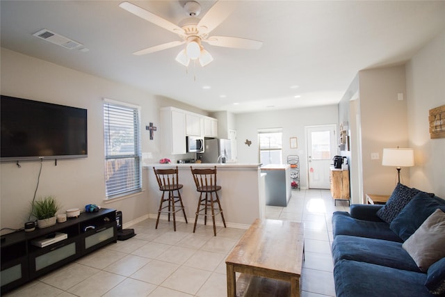 tiled living room featuring ceiling fan