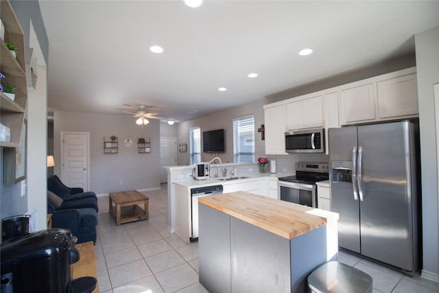 kitchen with kitchen peninsula, a center island, stainless steel appliances, and sink