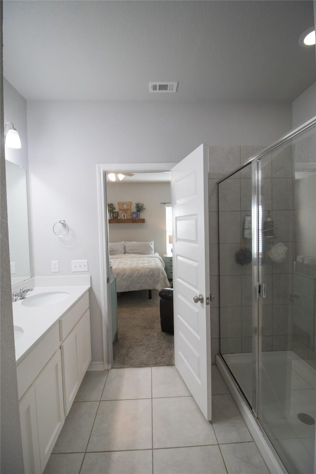 bathroom with vanity, tile patterned floors, and a shower with door