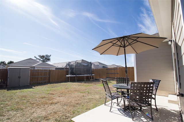 view of yard with a trampoline and a patio area