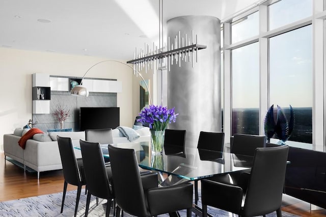 dining room with floor to ceiling windows, an inviting chandelier, and hardwood / wood-style flooring