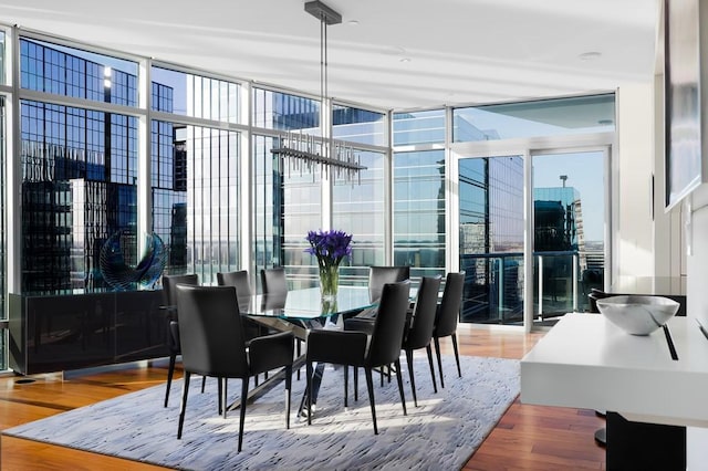 dining area with hardwood / wood-style flooring and an inviting chandelier