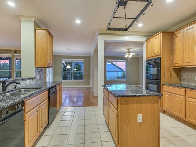 kitchen featuring sink, a kitchen island, dark stone countertops, and black appliances