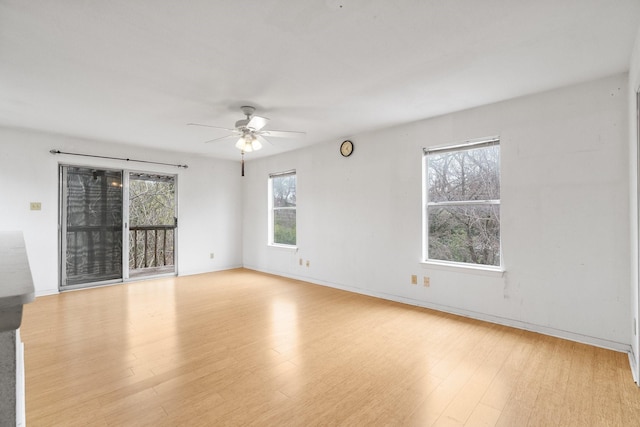 empty room featuring ceiling fan, light hardwood / wood-style floors, and a wealth of natural light