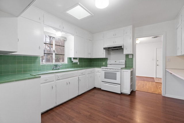 kitchen featuring electric range, dark hardwood / wood-style flooring, white cabinets, and sink