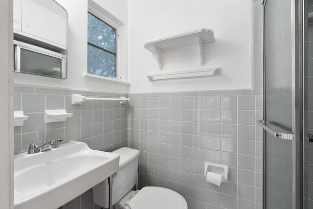 bathroom featuring sink, tile walls, and toilet