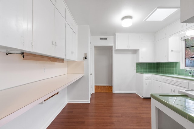 kitchen with decorative backsplash, dark hardwood / wood-style flooring, white cabinetry, and sink