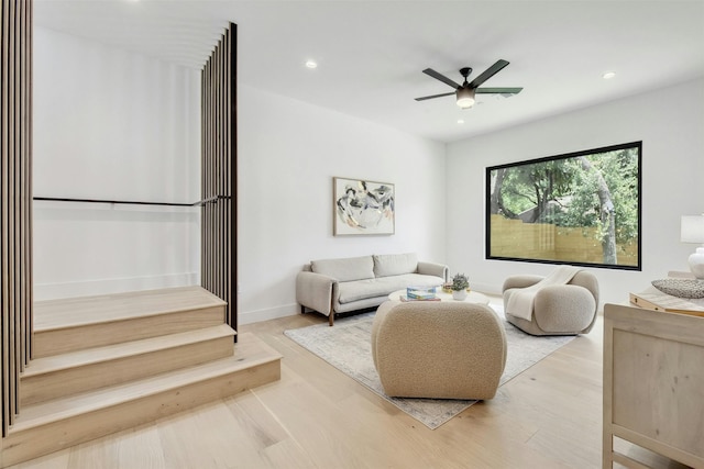 living room featuring ceiling fan and light hardwood / wood-style flooring