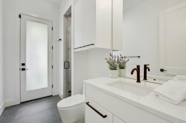 bathroom featuring vanity, a shower with shower door, and toilet