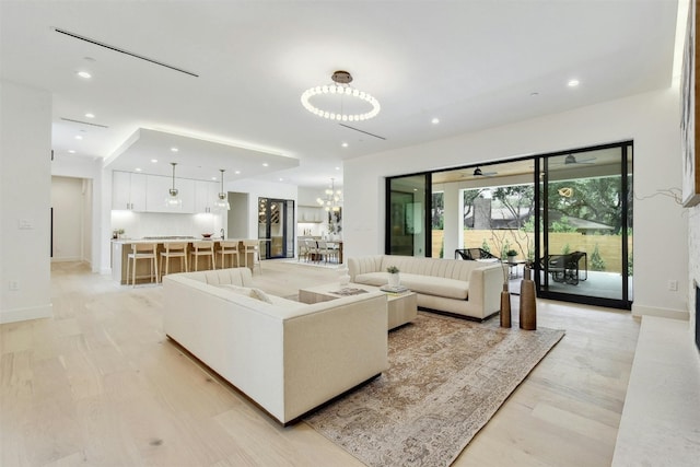 living room with a chandelier and light hardwood / wood-style flooring