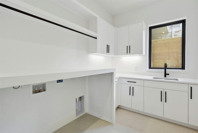 clothes washing area with washer hookup, cabinets, and sink