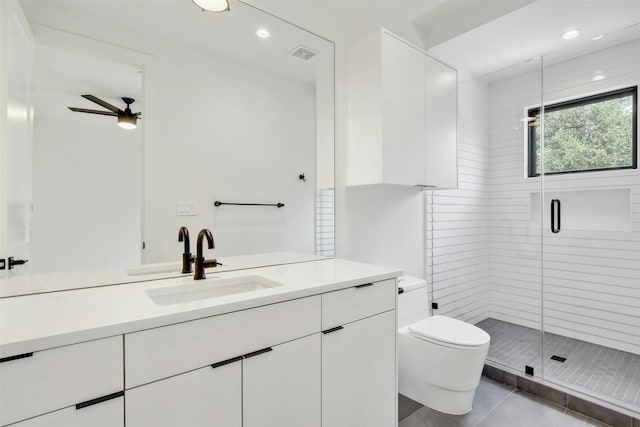 bathroom featuring vanity, a shower with door, tile patterned floors, ceiling fan, and toilet