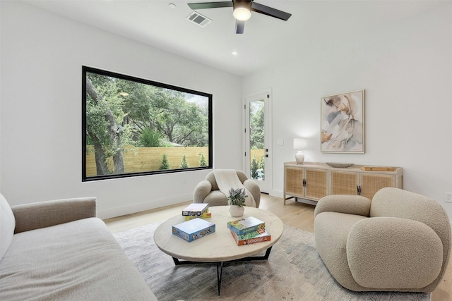 living room featuring light wood-type flooring and ceiling fan