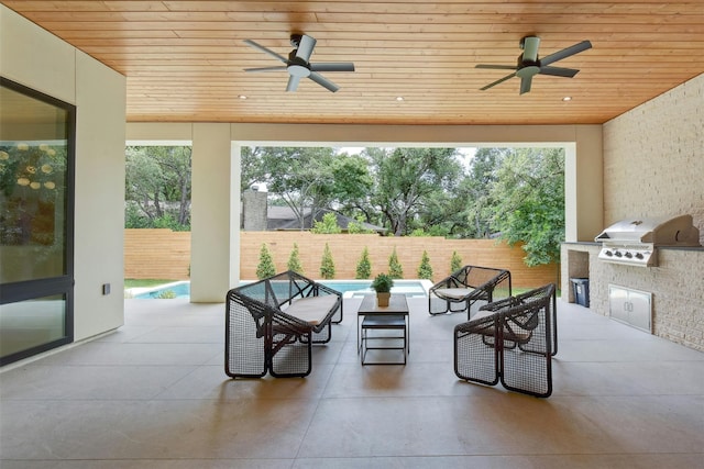 view of patio / terrace featuring ceiling fan, a grill, and exterior kitchen