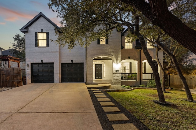 view of front of property featuring a garage and a lawn