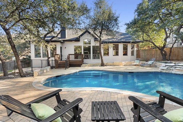 view of swimming pool featuring a deck and a patio