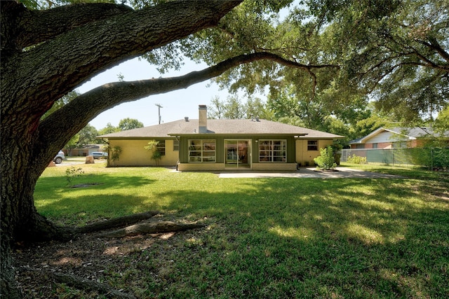 rear view of property with a lawn