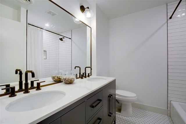 bathroom featuring toilet, vanity, and tile patterned floors