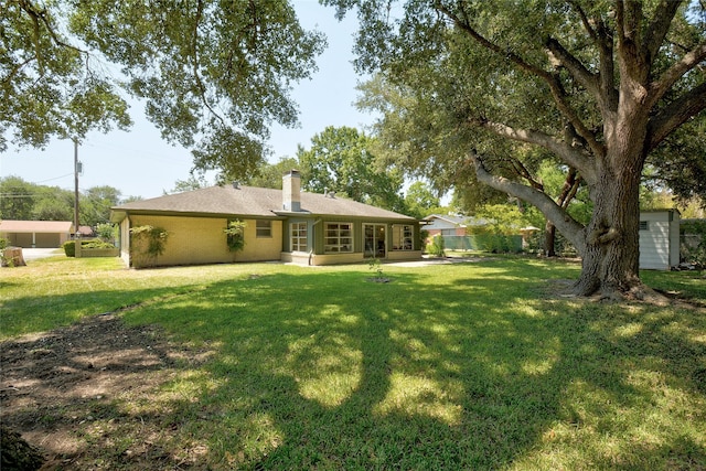 rear view of house with a patio and a lawn