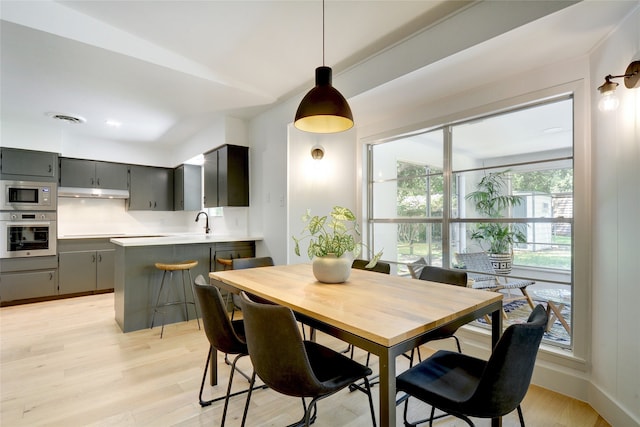 dining room featuring sink and light wood-type flooring