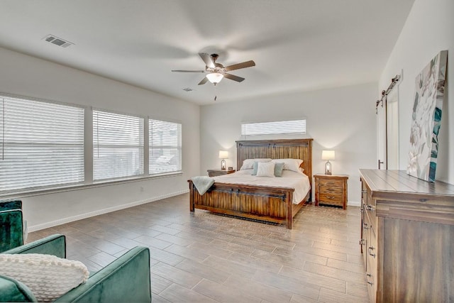 bedroom featuring a barn door and ceiling fan