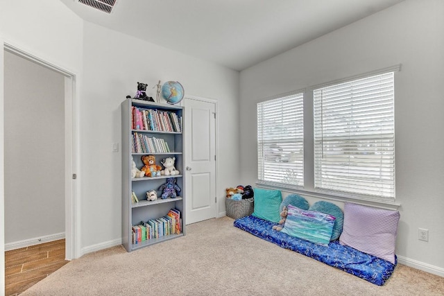 living area featuring light carpet