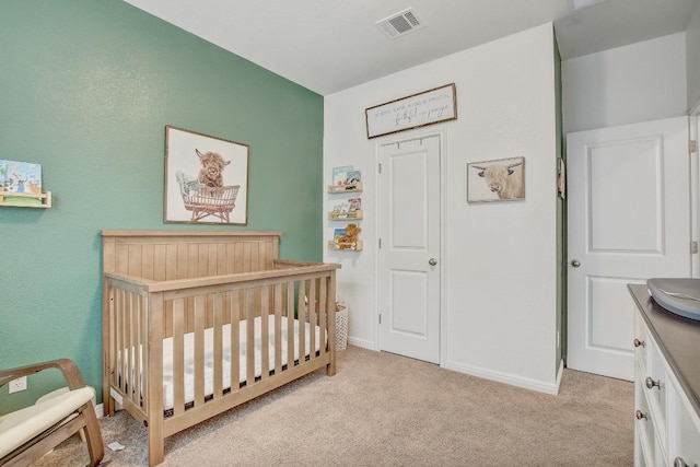 bedroom featuring a crib and light carpet