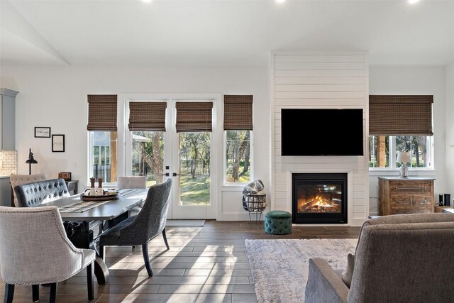 dining room featuring a fireplace, french doors, dark hardwood / wood-style flooring, and plenty of natural light