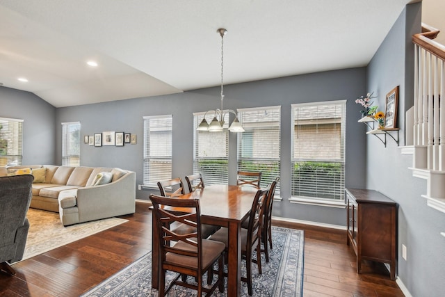 dining area featuring a chandelier, lofted ceiling, and dark wood-type flooring