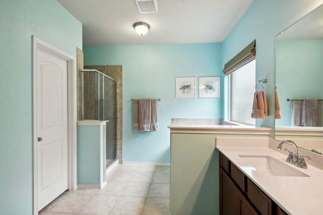 bathroom featuring tile patterned flooring, vanity, and walk in shower